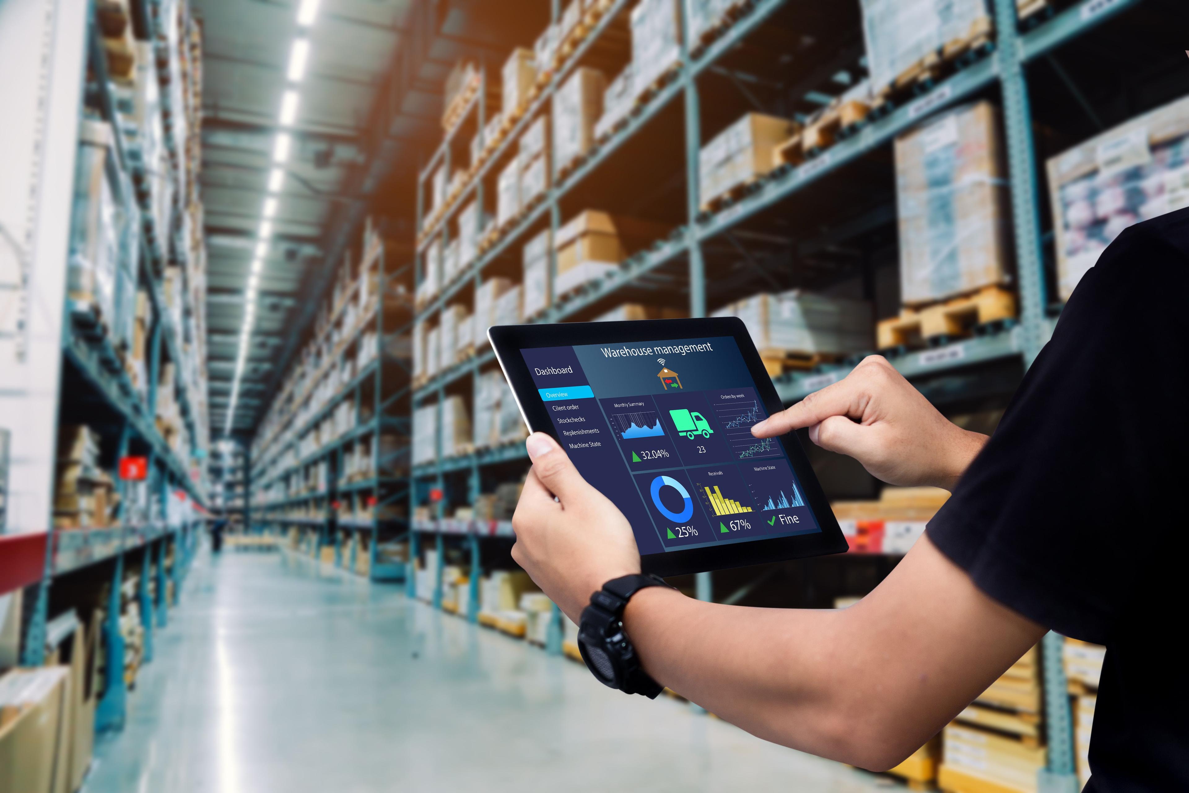 Warehouse management dashboard on tablet in modern logistics hall