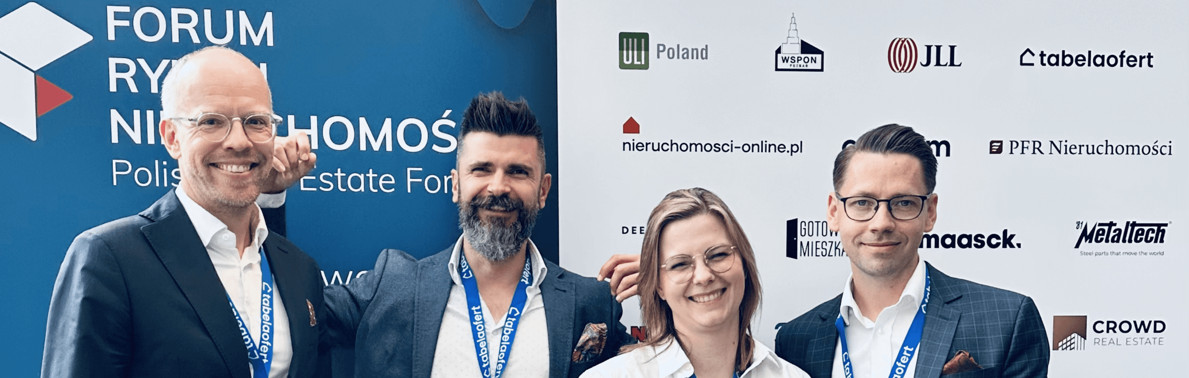 Czworo przedstawicieli JLL stojących na czerwcowym wydarzeniu w Sopocie przed ścianką z napisem "Forum Rynku Nieruchomości - Polish Real Estate Forum".