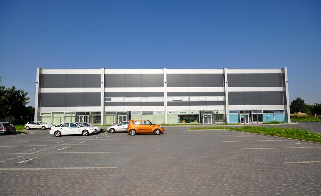 Zdjęcie przedstawia parking Airport House, w dalszym planie budynek biurowo-magazynowy ,,A''.