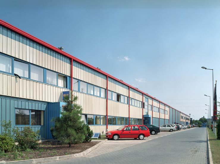 Zdjęcie ukazuje samochody na parkingu Logistics Center Kraków I, w tle widoczna część biurowa.