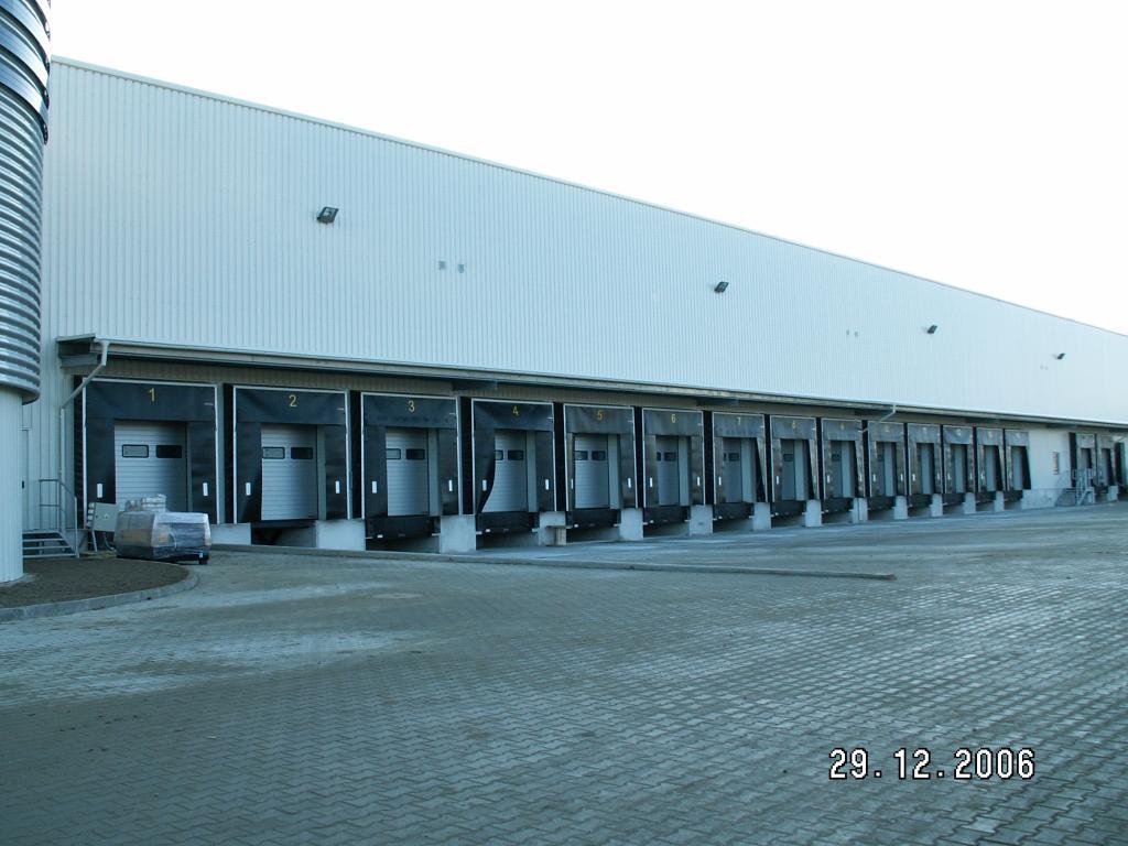 Zdjęcie prezentuje plac manewrowy Logistic Center Pruszcz Gdański, w tle budynek magazynowy z 15 dokami.