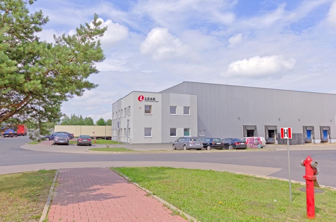 Zdjęcie prezentuje parking MLP Tychy, w tle widać budynek biurowy oraz fragment magazynu  ,,B1’’.
