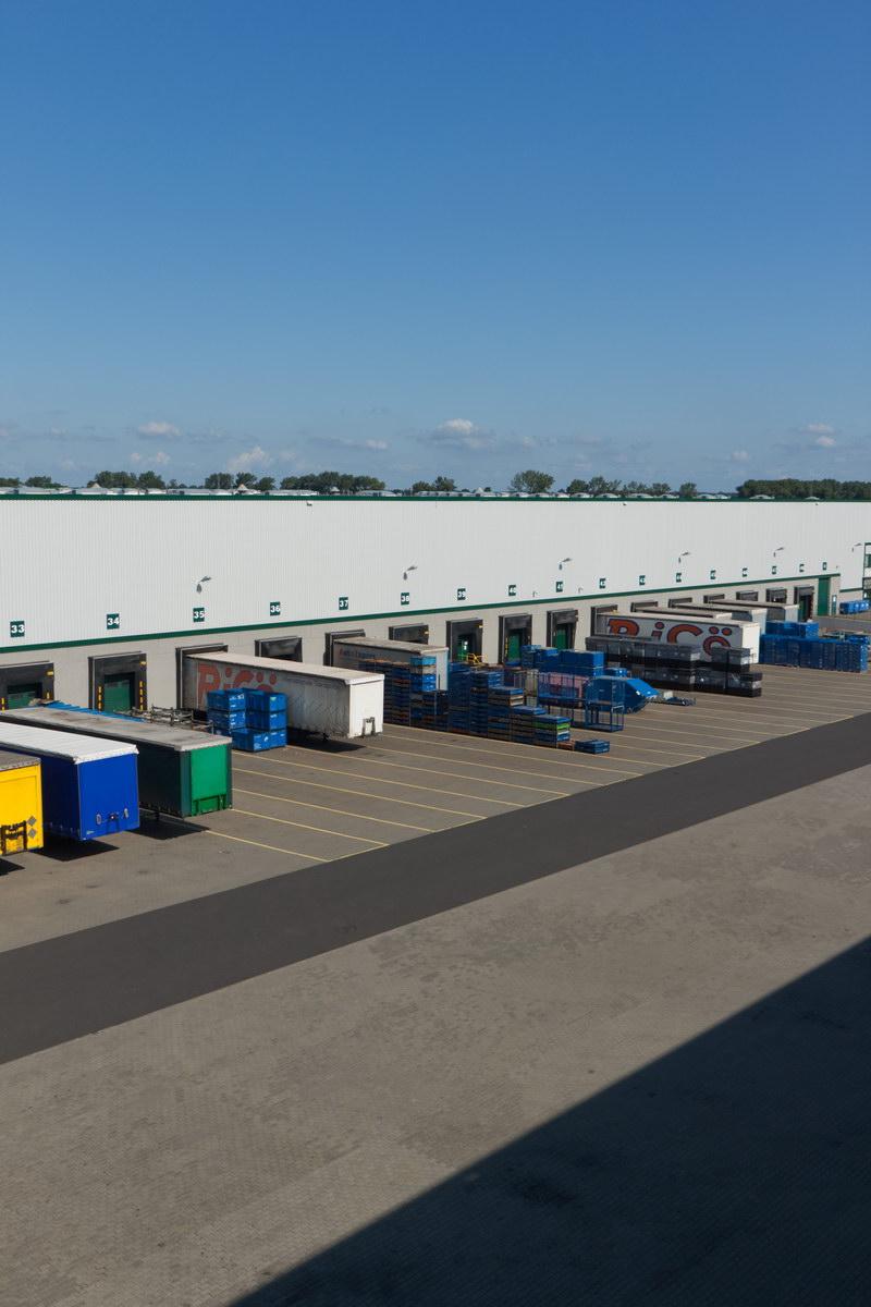 Zdjęcie lotnicze ukazuje fragment placu manewrowego Prologis Park Poznań I, w tle naczepy gotowe do załadunku.