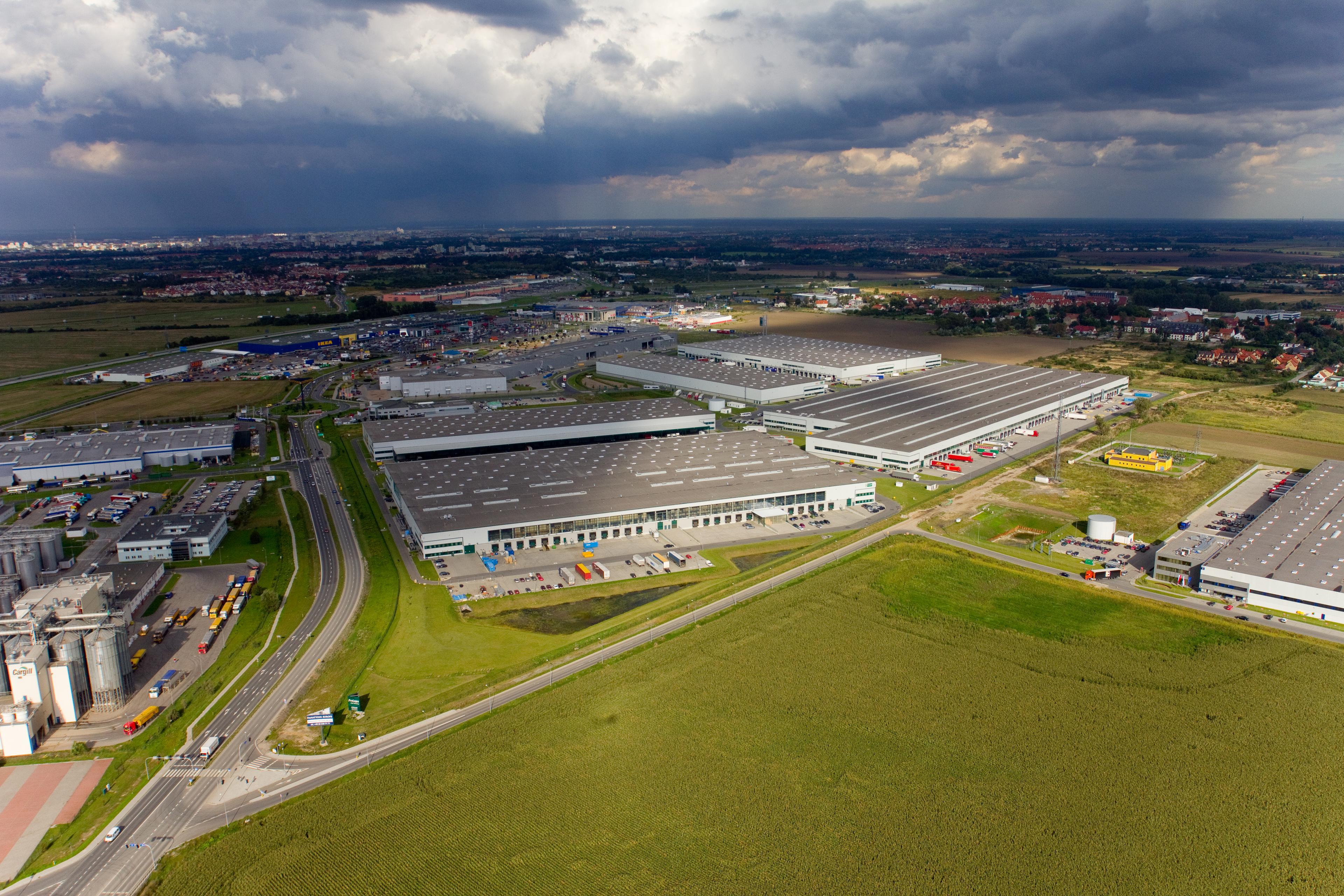 Zdjęcie lotnicze ukazuje obiekty magazynowe Prologis Park Wrocław I w pochmurny dzień.