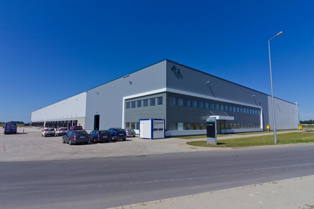 Zdjęcie ukazuje samochody na parkingu Prologis Park Wrocław V, w tle widoczna część biurowa magazynu ''DC 2''.