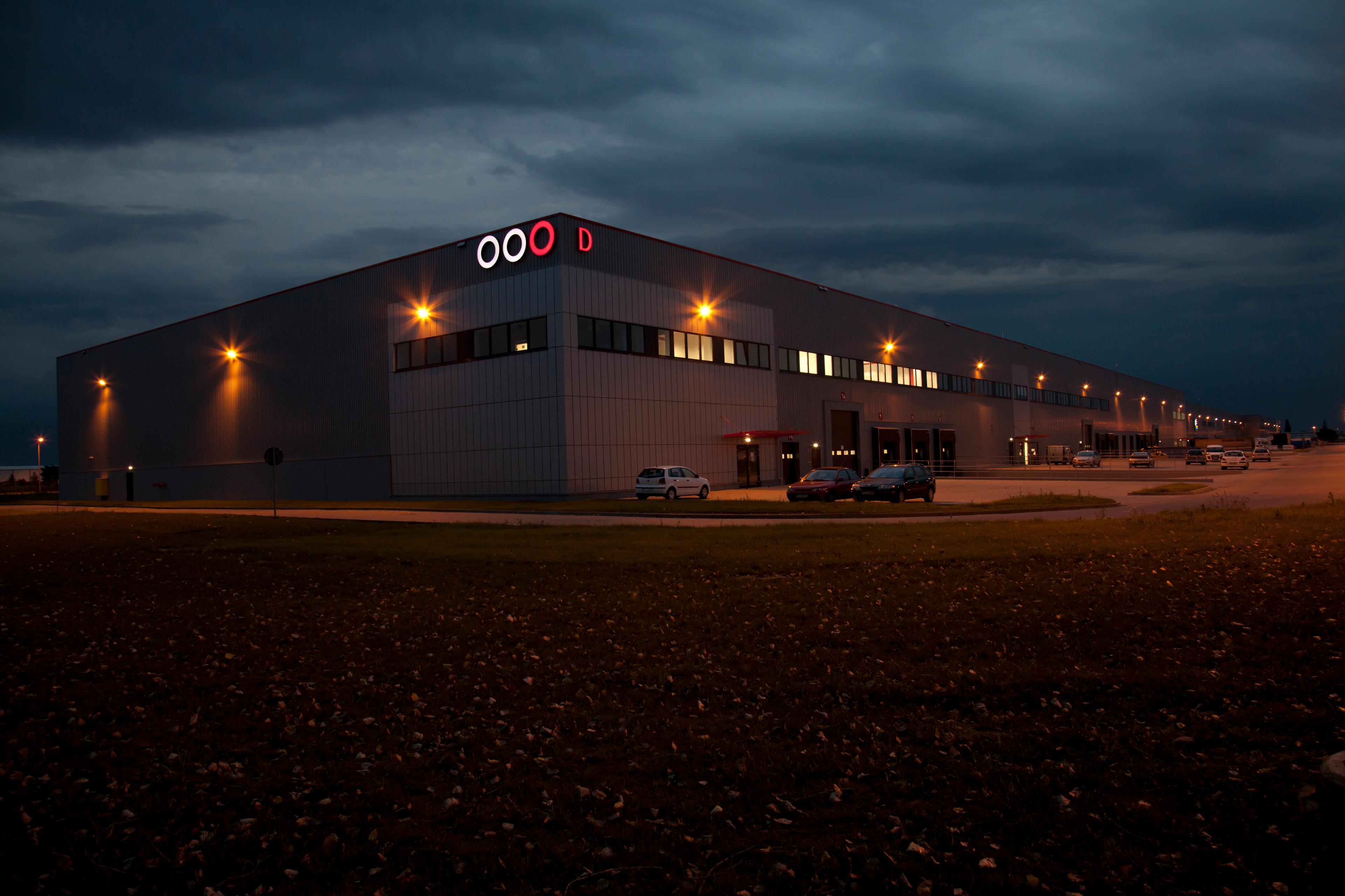 Zdjęcie zrealizowane nocą, prezentuje oświetlony budynek magazynowy ''D'' Segro Logistics Park Poznań.